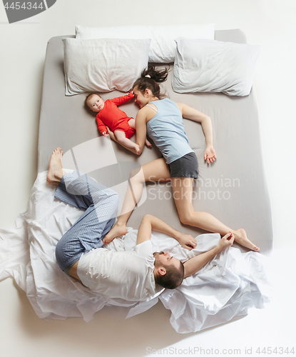 Image of Top view of happy family with one newborn child in bedroom.