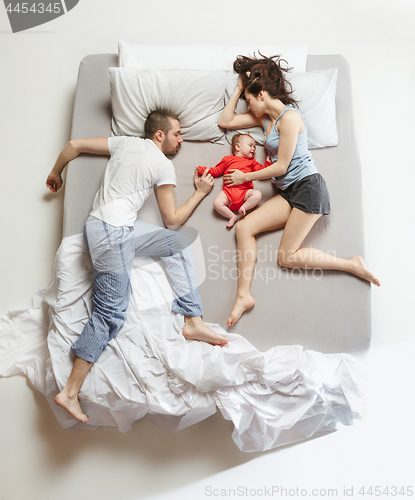 Image of Top view of happy family with one newborn child in bedroom.