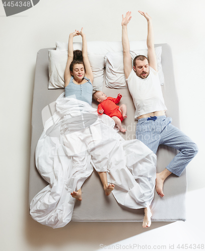 Image of Top view of happy family with one newborn child in bedroom.