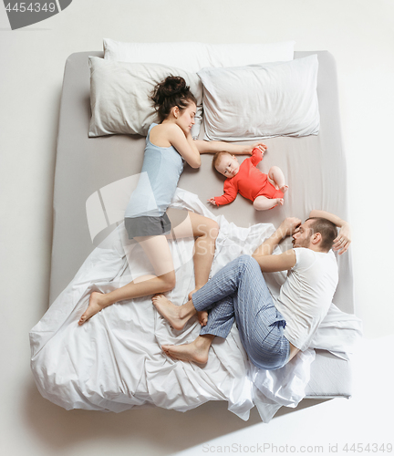 Image of Top view of happy family with one newborn child in bedroom.