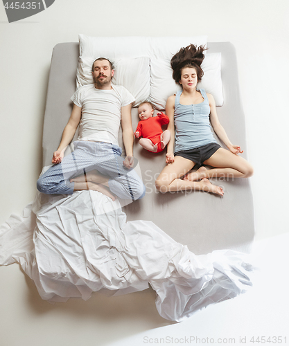 Image of Top view of happy family with one newborn child in bedroom.