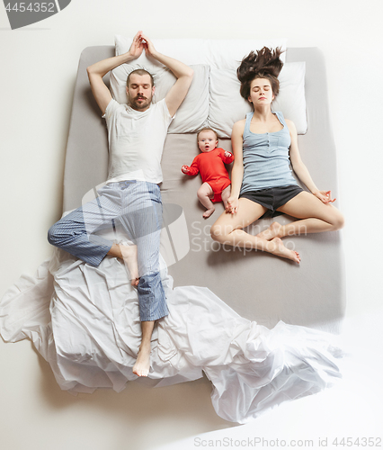 Image of Top view of happy family with one newborn child in bedroom.