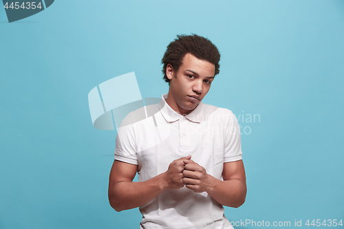 Image of Let me think. Doubtful pensive man with thoughtful expression making choice against blue background