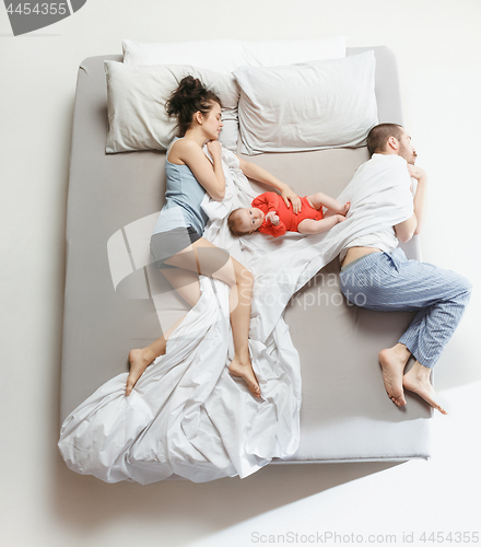 Image of Top view of happy family with one newborn child in bedroom.