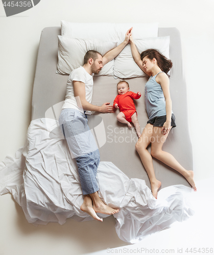 Image of Top view of happy family with one newborn child in bedroom.