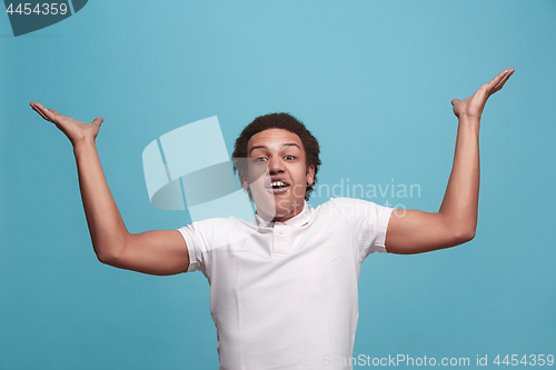 Image of The young attractive man looking suprised isolated on pink