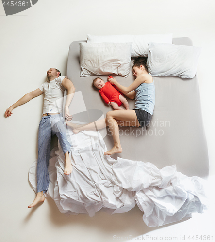 Image of Top view of happy family with one newborn child in bedroom.