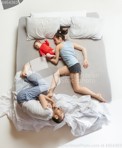 Image of Top view of happy family with one newborn child in bedroom.
