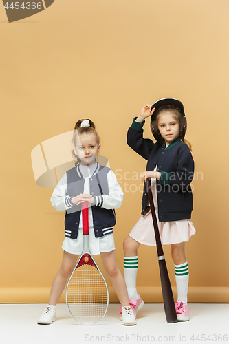 Image of Portrait of two girls as tennis players holding tennis racket. Studio shot.