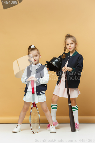Image of Portrait of two girls as tennis players holding tennis racket. Studio shot.