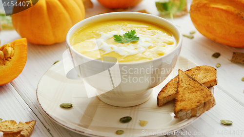 Image of Pumpkin soup in bowl served with bread