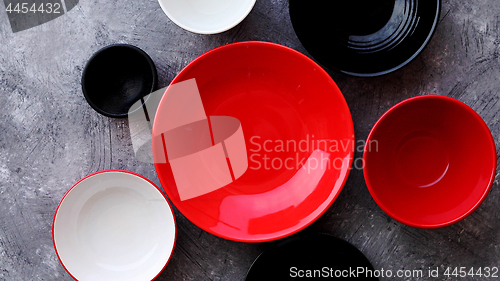 Image of Collection of empty colorful decorative ceramic bowls on grey stone background.