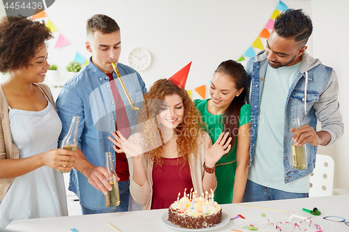 Image of happy coworkers with cake at office birthday party