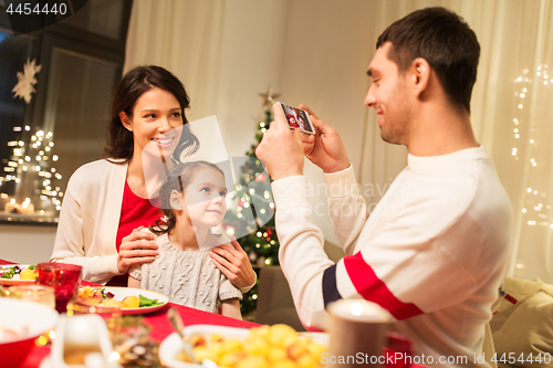 Image of happy family taking picture at christmas dinner