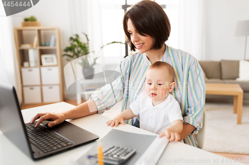 Image of working mother with baby boy and laptop at home