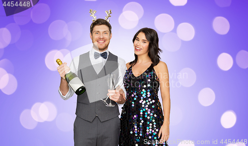 Image of couple with champagne bottle at christmas party