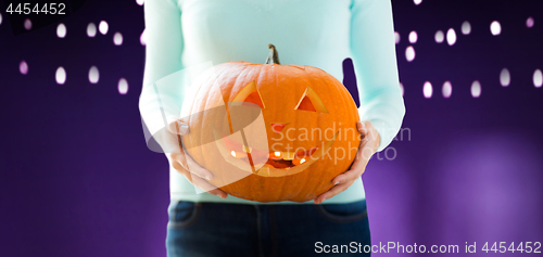 Image of close up of woman holding halloween pumpkin