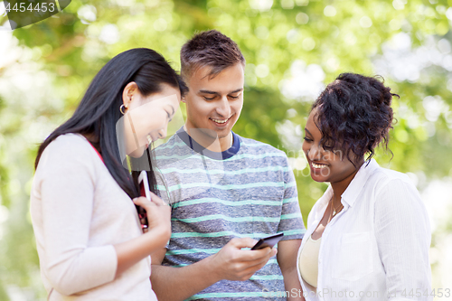 Image of group of happy friends with smartphone outdoors