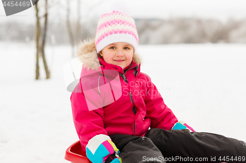 Image of happy little girl on sled outdoors in winter