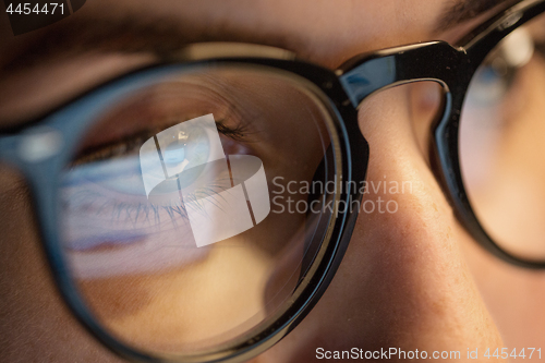 Image of close up of woman in glasses looking at screen