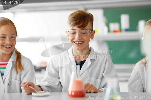 Image of kids with test tube studying chemistry at school