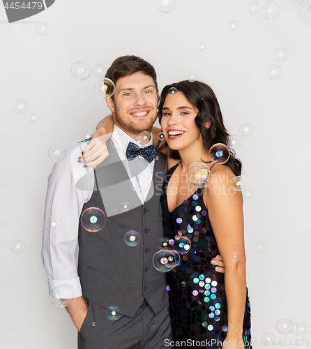 Image of happy couple hugging in soap bubbles at party