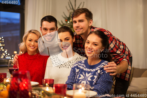 Image of happy friends celebrating christmas at home