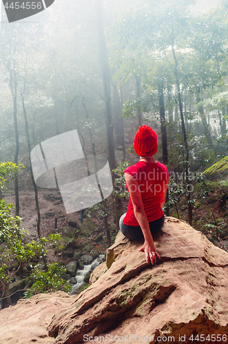 Image of Female taking shelter from the rain in a cave overhang Blue Mountains