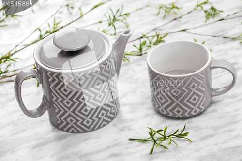 Image of Ceramic teapot and cup on marble surface