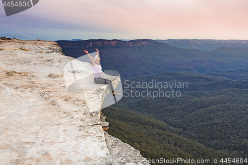 Image of Live your life to the full. Girl on cliff ledge