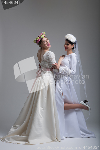 Image of Portrait of two beautiful young bride in wedding dresses