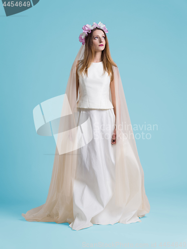 Image of beautiful woman wearing wedding dress against cyan background