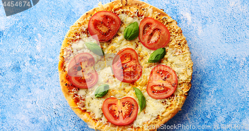 Image of Pizza with cheese and tomatoes on blue stone table