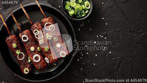 Image of Barbecued turkey kebab decorated with fresh onion