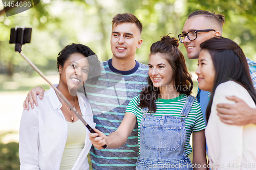 Image of international friends taking selfie in park