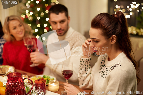 Image of woman calling on smartphone at christmas dinner