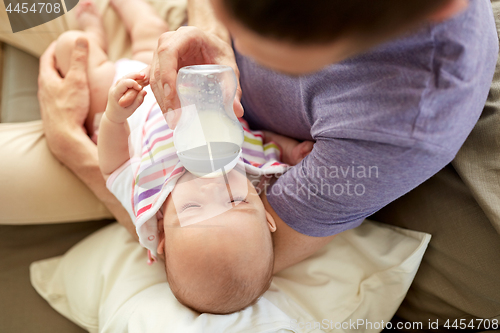 Image of close up of father feeding baby from bottle