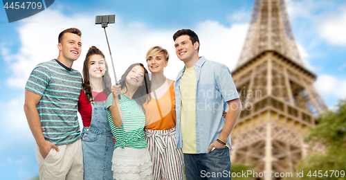 Image of friends taking selfie by monopod over eiffel tower