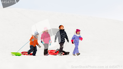 Image of happy little kids with sleds in winter