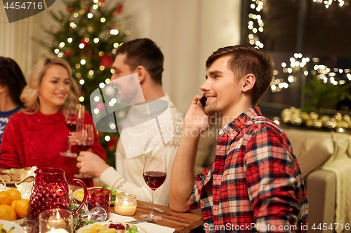 Image of man calling on smartphone at christmas dinner