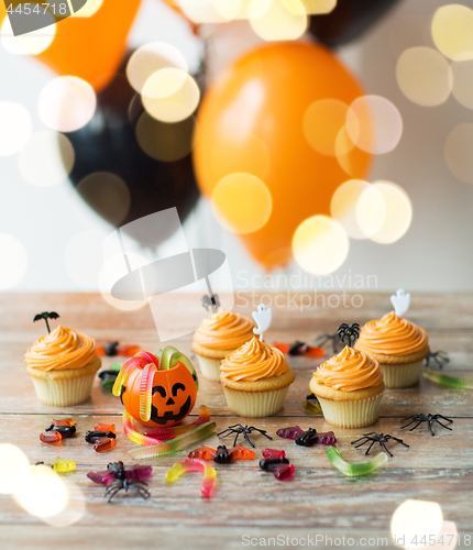 Image of halloween party decorated cupcakes on wooden table