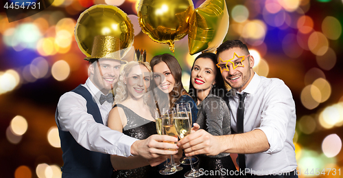 Image of happy friends clinking champagne glasses at party