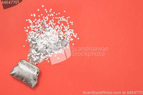 Image of Shiny hearts and silver purse on pink background