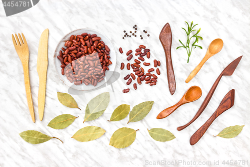 Image of Beans, spices and wooden utensils on marble background