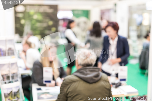 Image of Anonymous blurred people discussing business at a trade fair.