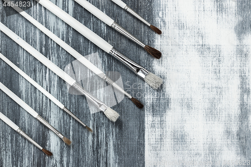 Image of Paintbrushes on artistic background with gray brush strokes