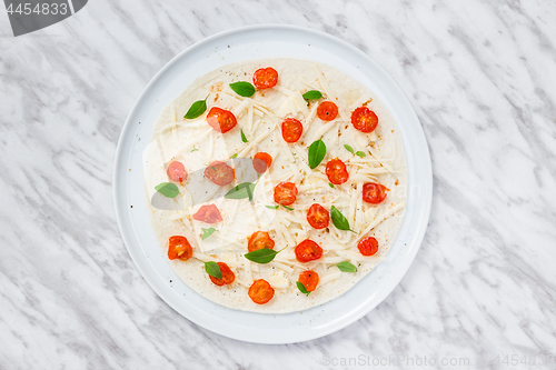 Image of Preparing a tortilla with tomatoes, cheese and basil