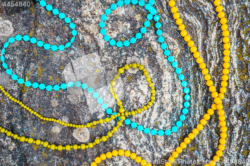 Image of Colorful necklaces on mossy rock background