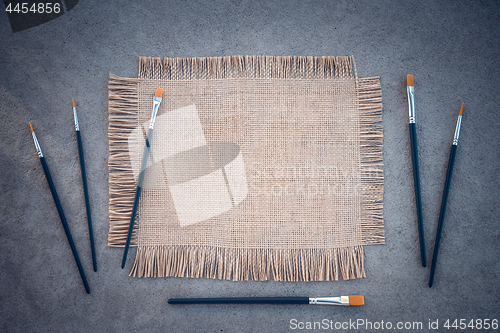 Image of Paintbrushes and canvas on concrete background