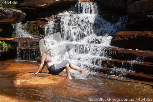 Image of Female splashing her feet in cascading waterfall